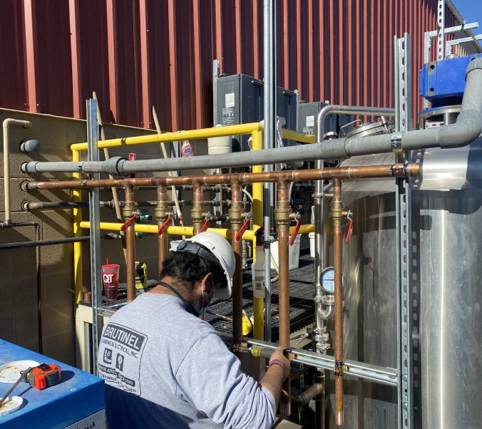 A man working on pipes in an industrial setting.