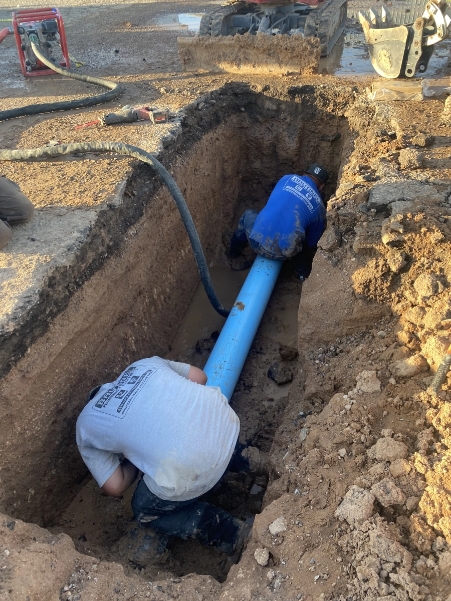 A man is working on the side of a pipe.